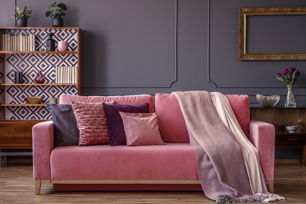 sofa w kolorze maliny i szara ściana malinowa kanapa w pokoju z szarą ścianą